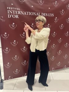 Sandrine Mercy devant le panneau du Festival des Lys d’Or avant la cérémonie de remise des prix